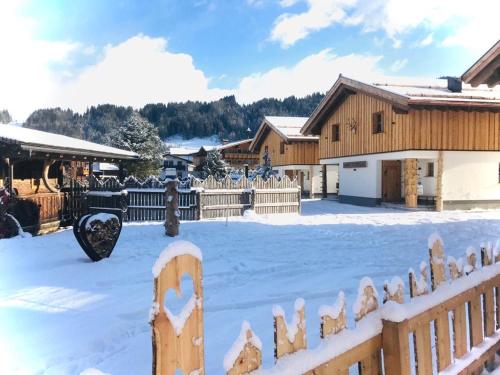 a fence covered in snow next to a building at Sieglhub Chalets - Appartements - Hotel in Flachau