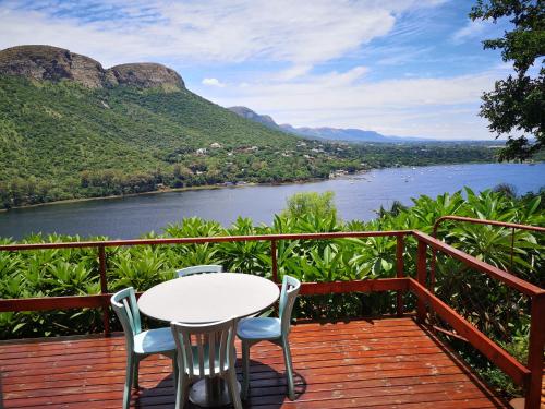 a table and chairs on a deck with a view of a river at Letamong in Hartbeespoort