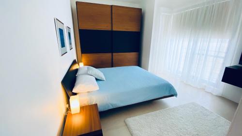 a bedroom with a blue bed with a wooden headboard at Gozo Dwejra Views in San Lawrenz