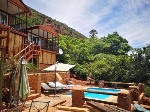 a resort with a swimming pool in front of a mountain at Letamong in Hartbeespoort
