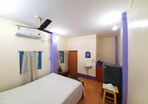 a bedroom with a white bed and a sink at Dden Vennell BnB -Metro Access- in Kolkata