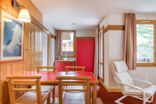 ein Esszimmer mit einem roten Tisch und Stühlen in der Unterkunft Résidence DIGITALE, Le Lauze Plagne 1800 in Plagne 1800