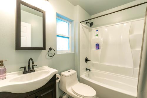 La salle de bains est pourvue d'un lavabo, de toilettes et d'une baignoire. dans l'établissement Ocean Breeze Inn, à Keaau