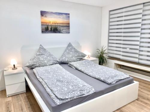 une chambre blanche avec un lit et une fenêtre dans l'établissement Ferienwohnung Wasserkunst, à Bad Harzburg