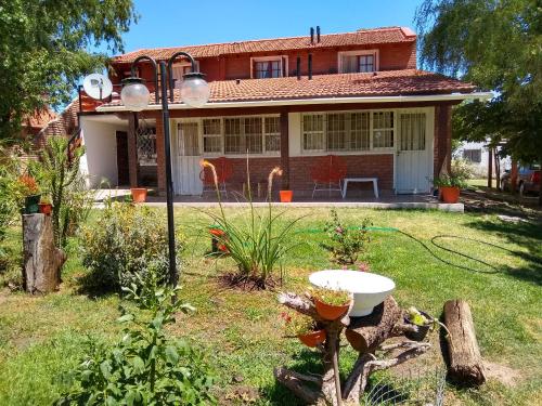 una casa con un jardín delante de ella en Complejo Viejo Sulky en Mina Clavero