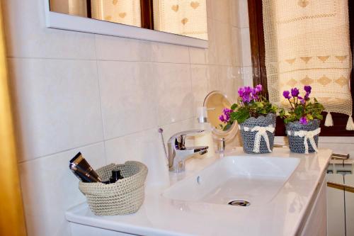 un lavabo de salle de bain avec deux vases de fleurs dessus dans l'établissement Ca' All'Arco, à Venise