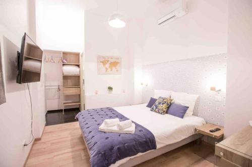 une chambre avec un lit et une télévision dans une pièce dans l'établissement La Cour du Faubourg 1 (LCDF1), à Strasbourg