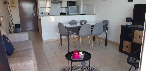 un salon avec une table et des chaises et une cuisine dans l'établissement Mini villa n2, à Olmeto