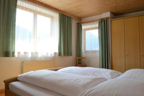 ヴィルゲンにあるFerienwohnung Kogelblickのベッドルーム(窓2つ付)のベッド2台
