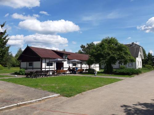 een huis met een rood dak en een grasveld bij PENSJONAT FARYNY in Faryny