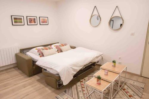 une chambre avec un lit et un miroir au mur dans l'établissement La Cour du Faubourg 2 (LCDF2), à Strasbourg