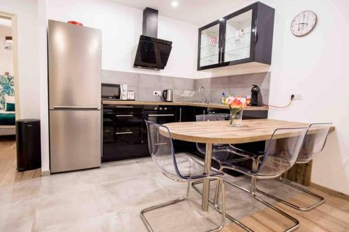 une cuisine avec une table et un réfrigérateur en acier inoxydable dans l'établissement La Cour du Faubourg 2 (LCDF2), à Strasbourg