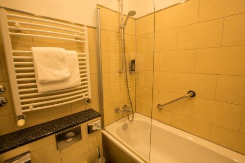 a bathroom with a shower and a tub and a sink at Top Hotel Hammer - Mainz Hauptbahnhof in Mainz