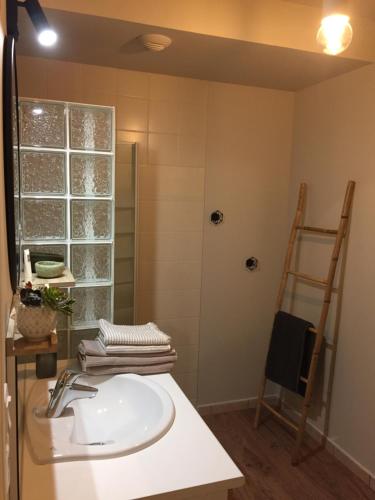 baño con lavabo, ventana y escalera en Bel appartement la Forêt-Fouesnant vue sur la baie, en La Forêt-Fouesnant
