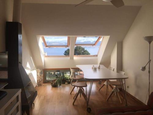 Habitación con mesa, sillas y ventana en Ático Masso, en Cangas de Morrazo