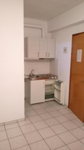 an empty kitchen with white cabinets and a sink at Filaktos Studios in Skala Sotiros