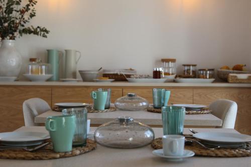 a table with plates and glasses on top of it at Quinta do Barreiro in Borba