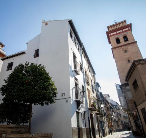 格拉納達的住宿－Casa Flor del Naranjo，街道上一座白色的建筑,有钟楼