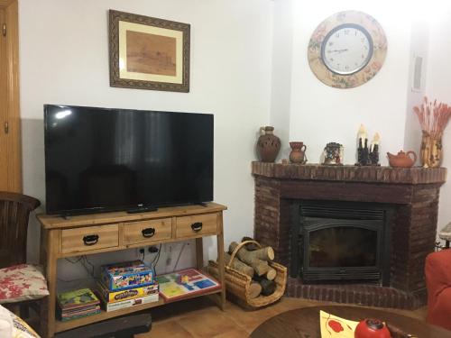 a living room with a television and a fireplace at Chalet El Descanso in Rades de Abajo