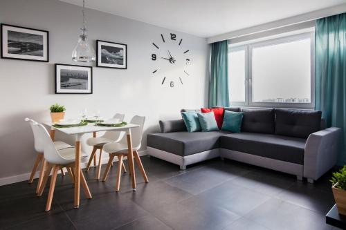 a living room with a couch and a table at WarsawSkyLine Apartments - PGE Narodowy, Torwar, Bulwary Wiślane in Warsaw