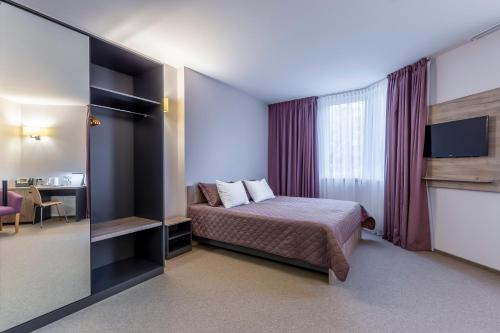 a hotel room with a bed and a tv at Favor Sport Hotel in Kyiv