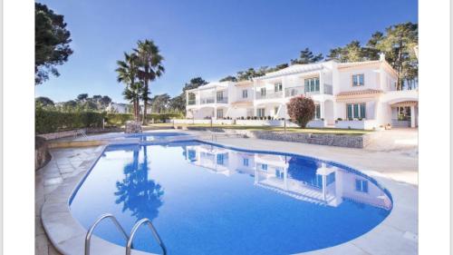 una gran piscina frente a una casa en Algarve Albufeira, quiet apart with pool at 10 mn walk from Praia da Falesia en Olhos de Água