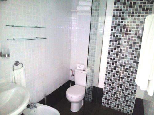 a bathroom with a white toilet and a sink at Azahara Beach 416 in Los Cristianos