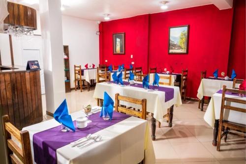 a restaurant with two tables and a red wall at La Casa de Anita in Chivay