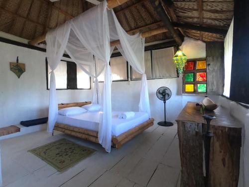 a bedroom with a bed with white drapes at CASA BARCA in Taganga