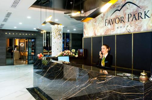 キーウにあるFavor Park Hotelのロビーの携帯電話で話している男