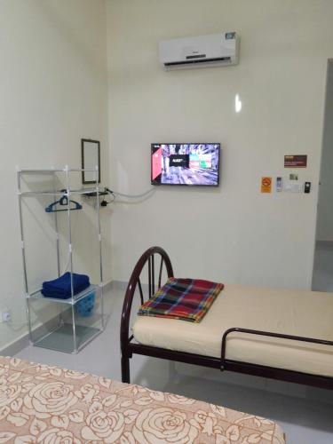 a hospital room with a bed and a tv on the wall at WeJDAN INN BALIK PULAU, PENANG ISLAND in Balik Pulau