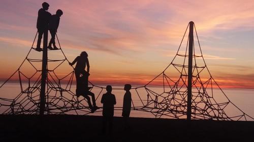 a group of people standing on top of a sculpture at sunset at Casa Piscina Branca in Touros