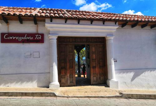 un bâtiment avec une porte en bois et un panneau. dans l'établissement Corregidora 12, à San Cristóbal de Las Casas