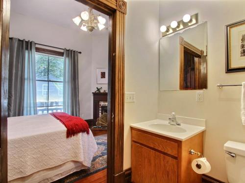 ein Bad mit einem Bett, einem Waschbecken und einem Spiegel in der Unterkunft Big Blue House - Near Forsyth Park - Lower Unit in Savannah
