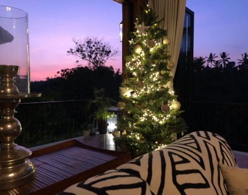 ein Weihnachtsbaum auf der Veranda eines Hauses in der Unterkunft Puri Kasih Gottlieb in Ubud