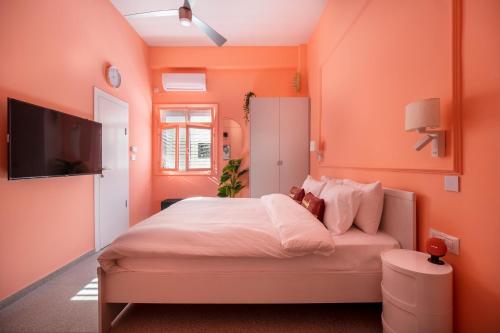 a bedroom with orange walls and a bed with a teddy bear on it at Glamorous Pink Pearl Studio/Beach/Parking/Netflix in Tel Aviv