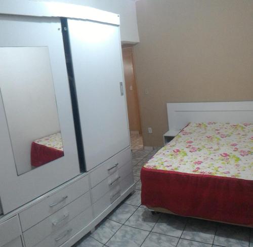- une chambre avec un lit et une commode avec un miroir dans l'établissement Casa em Prado com piscina - Temporada, à Prado