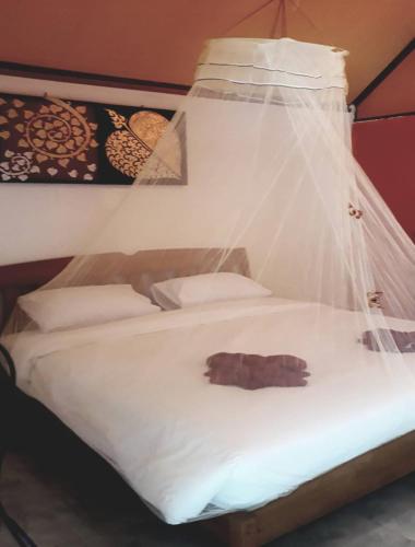 a bed with a net on top of it at Long Beach Garden Resort in Ko Lanta