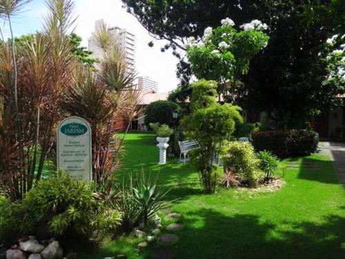 um jardim com plantas e um sinal na relva em Hotel Jardim em Fortaleza