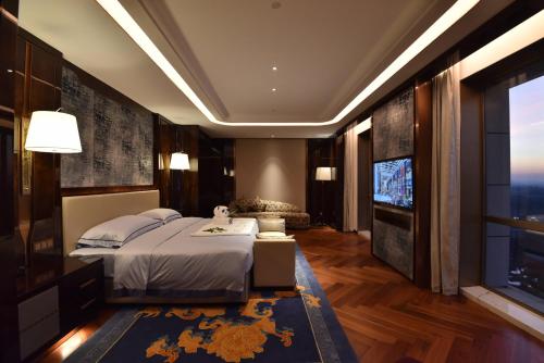 a bedroom with a large bed and a television at Vignette Collection Haikou Yatter Hotel by IHG in Haikou