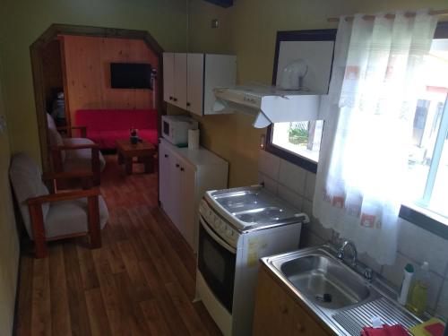 a small kitchen with a sink and a stove at Cabanas Yessi in Castro