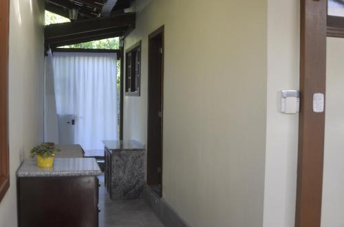 un pasillo con una mesa y una puerta a una habitación en Pousada mais confortável de Itapema, en Itapema