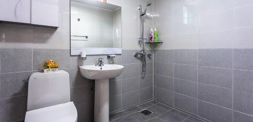 a bathroom with a toilet and a sink and a mirror at J&J pension in Seogwipo