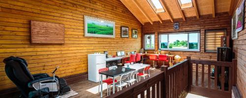 una vista interna di una baita di tronchi con sedie rosse di J&J pension a Seogwipo