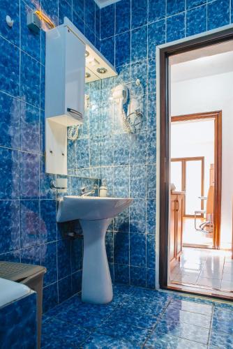 a blue tiled bathroom with a sink and a mirror at Azure Adriatic in Kotor
