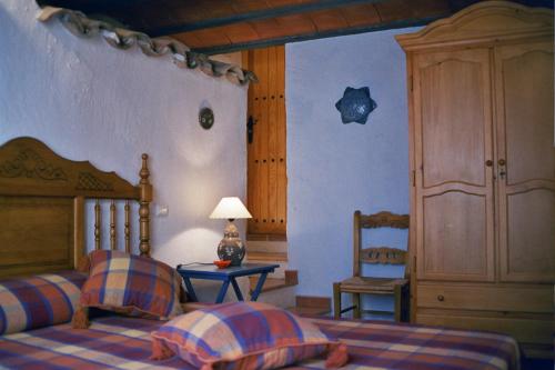 1 dormitorio con 1 cama y 1 mesa con lámpara en Casa Rural Albayacín, en Letur