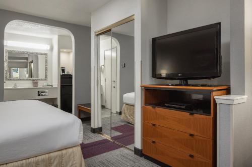 a bedroom with a bed and a flat screen tv at Atherton Park Inn and Suites in Redwood City