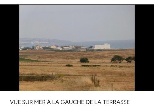 a view of a field with the words we spur men a la ga ga ga at TANGER/ASILAH: APPART 50m2 FACE MER ET PISCINES, 5 PLACES, TOUT ÉQUIPÉ+WIFI+CLIM in Briech