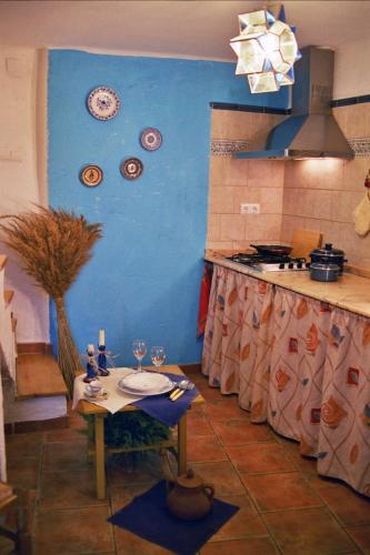a kitchen with a table and a blue wall at Casa Rural Albayacín in Letur