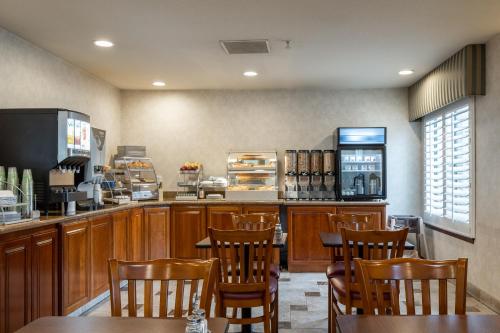a restaurant with wooden tables and chairs and a counter at Atherton Park Inn and Suites in Redwood City